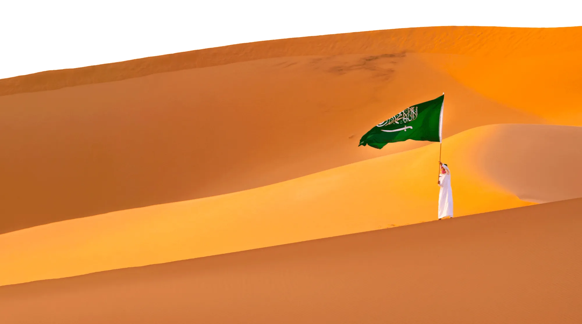 Pilger mit saudischer Flagge auf einer Sanddüne im Abendlicht